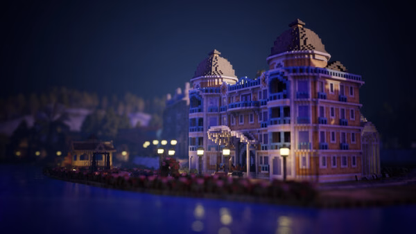 Screenshot from Town to City showing a grand, illuminated riverside mansion at night with a serene water reflection.