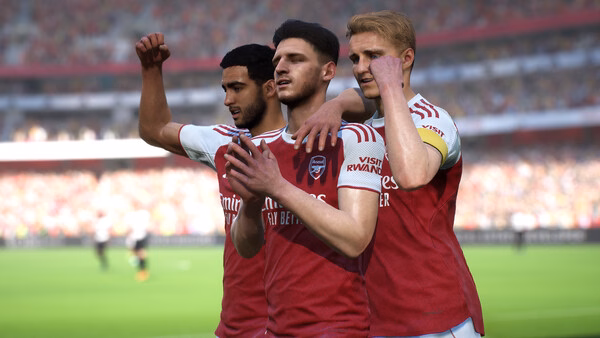eFootball™ screenshot showing three soccer players in red and white jerseys celebrating on a vibrant, crowded stadium field.