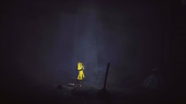 Screenshot from Little Nightmares showing a character in a yellow raincoat standing in a dark, eerie room with scattered debris.