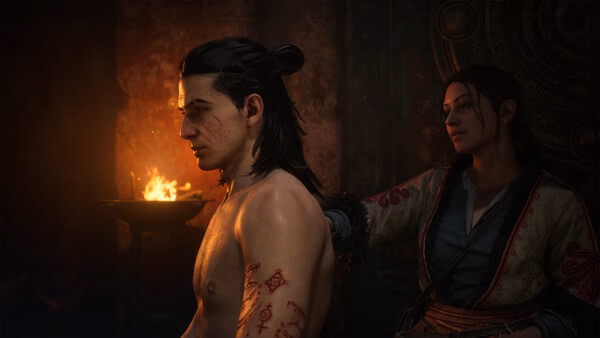 Screenshot from The Blood of Dawnwalker showing a tattooed man seated near a flame, with another character standing behind him.
