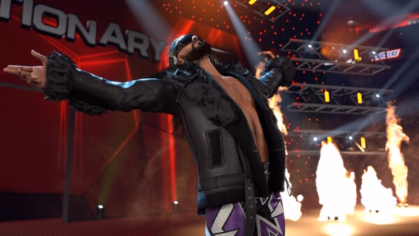 Screenshot from WWE 2K26 showing a wrestler in a black jacket, arms spread wide, surrounded by flames and stage lights.